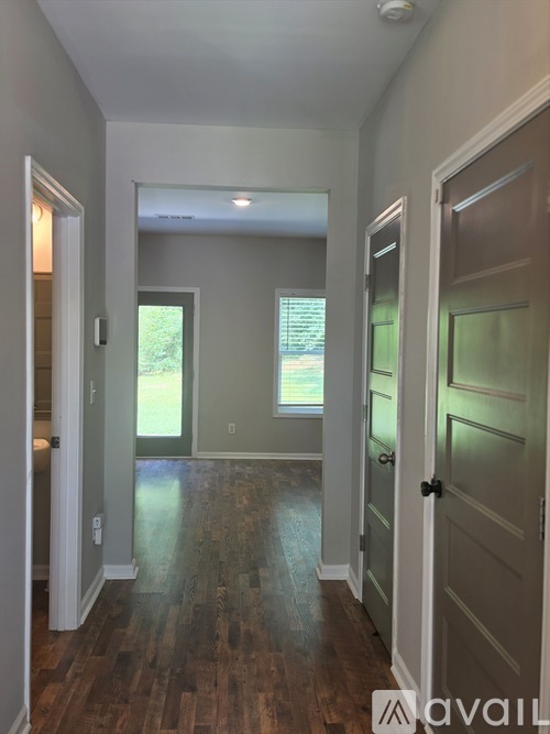 A hallway with wood floors and white walls.