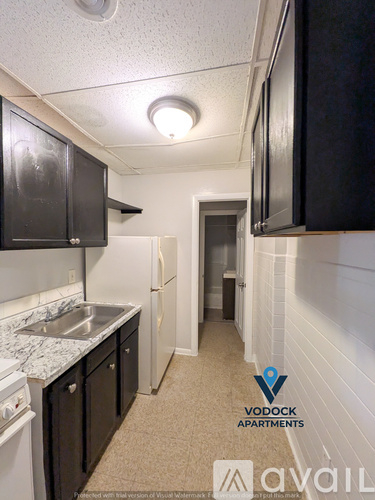 A kitchen with a sink and a refrigerator in a small apartment.