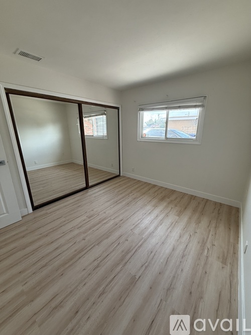 A room with wooden flooring and a window.