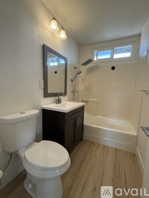 A bathroom with a toilet, sink, and bathtub.