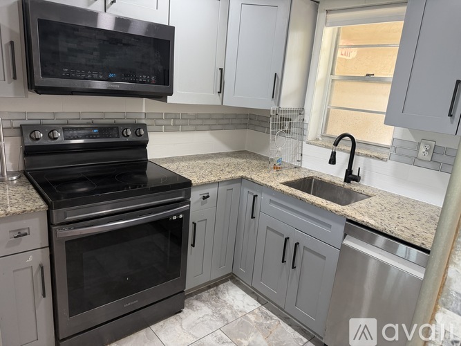 A kitchen with a black oven and a black microwave above it.