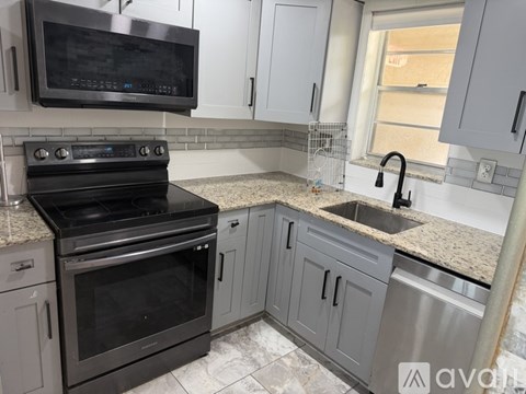 A kitchen with a black oven and a black microwave above it.