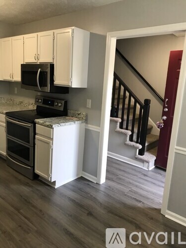 A kitchen with white cabinets and a black stove top oven.