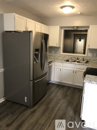 A kitchen with a refrigerator and cabinets.