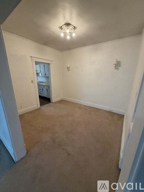 A room with a carpeted floor and a doorway leading to another room.