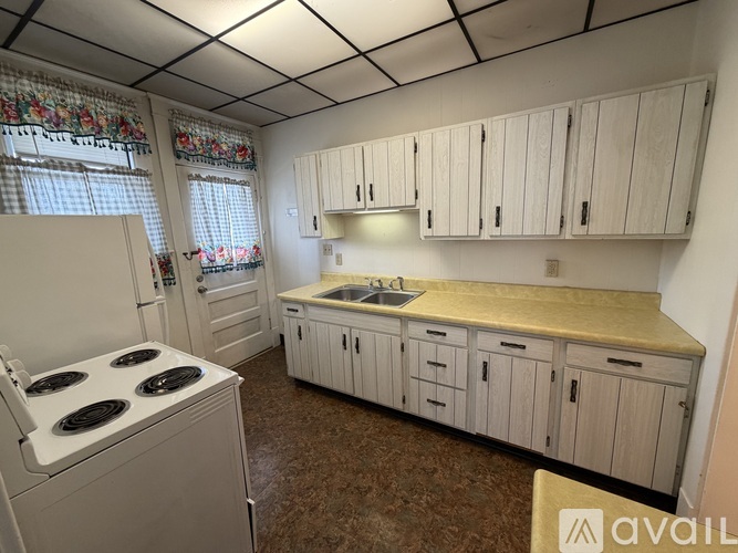 A kitchen with a stove, cabinets, and a countertop.