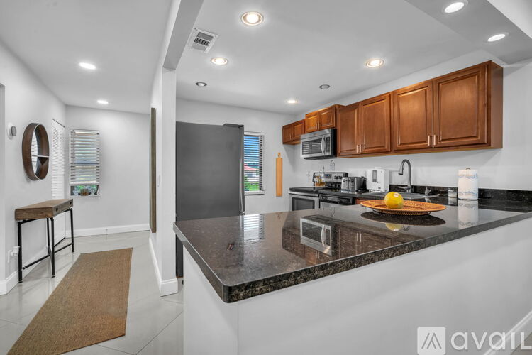 A kitchen with brown cabinets and a granite countertop.