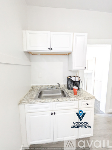 A kitchen with a Vodock Apartments logo on the counter.
