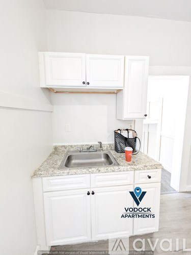 A kitchen with a Vodock Apartments logo on the counter.