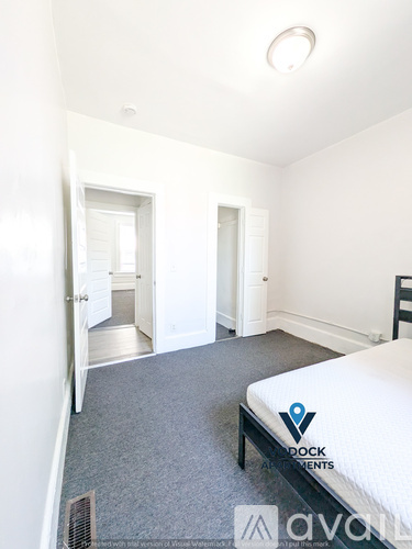 A bedroom with a bed, a chair, and a window.