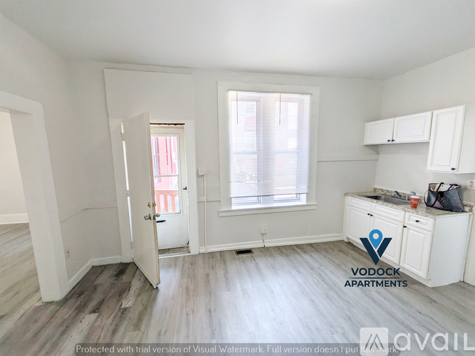 A white apartment with a door open to a hallway.