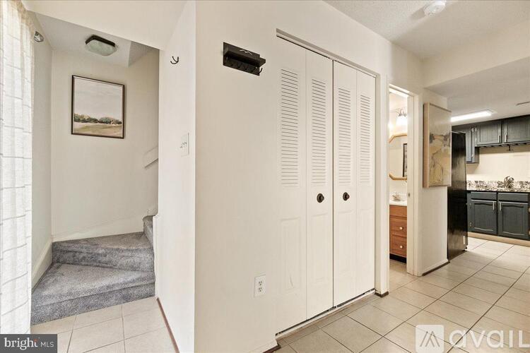 A white kitchen with a refrigerator, cabinets, and a stove top oven.