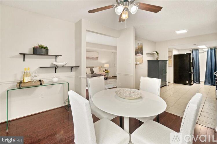 A dining room with a white table and chairs.