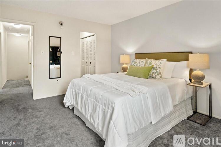 A bedroom with a large bed and a mirror on the wall.