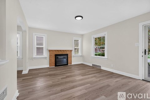 A living room with a fireplace and wood flooring.