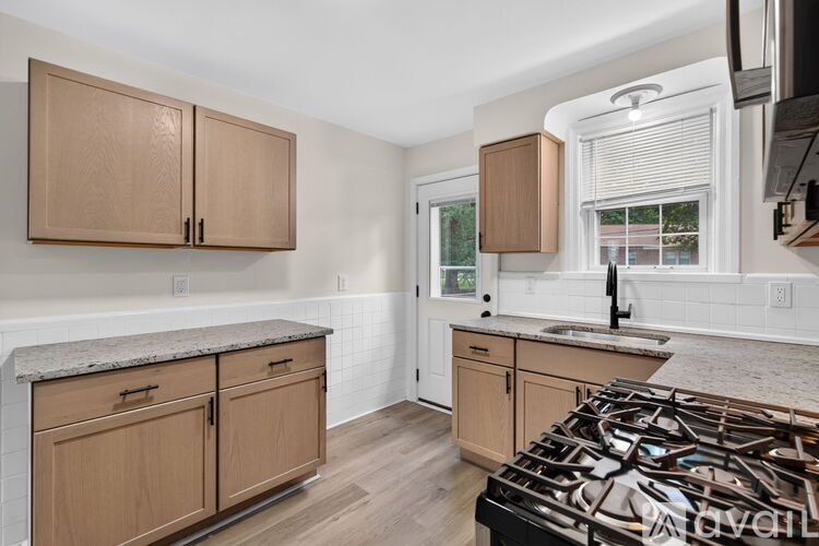 A kitchen with wooden cabinets and a black stove top.