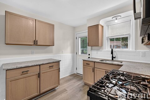 A kitchen with wooden cabinets and a black stove top.