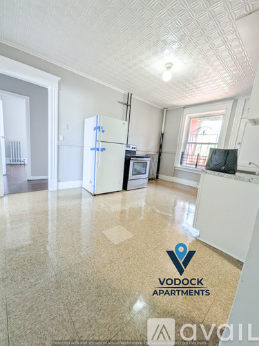 A kitchen with a refrigerator, microwave, and oven in a Vodock Apartments unit.