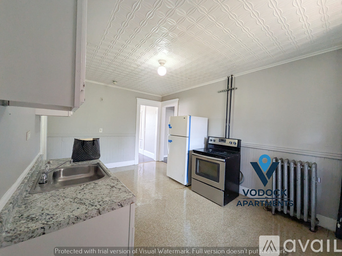 A kitchen with granite countertops and a Voddek Apartment logo.