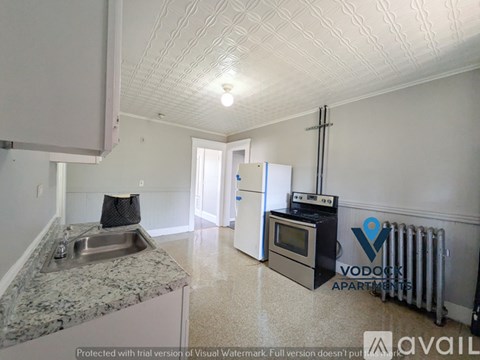 A kitchen with granite countertops and a Voddek Apartment logo.