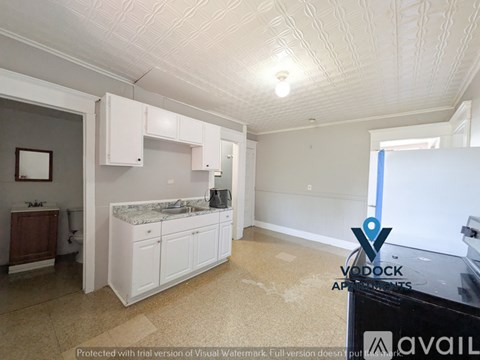 A kitchen with white cabinets and a countertop is shown.