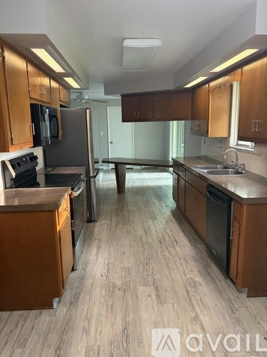 A kitchen with wooden cabinets and a refrigerator.