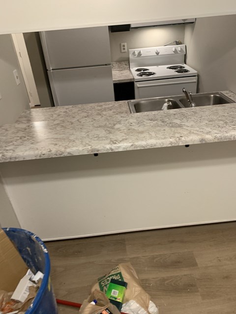 A kitchen with a granite countertop and a stove top oven.