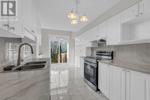 A modern kitchen with white cabinets and a marble countertop.