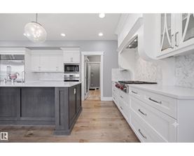 A modern kitchen with white cabinets and a dark island.
