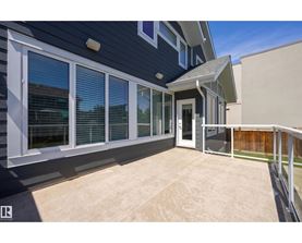 A house with a blue exterior and a patio with a white railing.