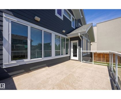 A house with a blue exterior and a patio with a white railing.