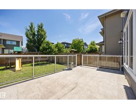 A backyard with a fence and a yellow trash can.