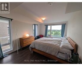 A bedroom with a bed, nightstand, and window.