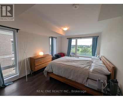 A bedroom with a bed, nightstand, and window.