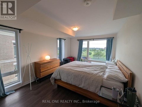 A bedroom with a bed, nightstand, and window.
