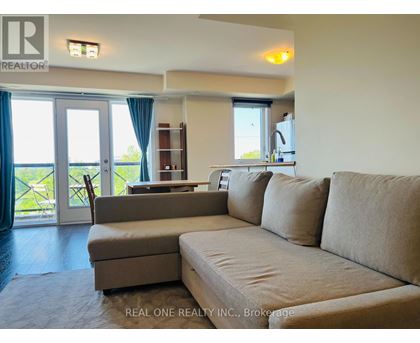 A living room with a couch, chair, and sliding glass doors.