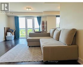 A living room with a couch, a chair, and a window with curtains.