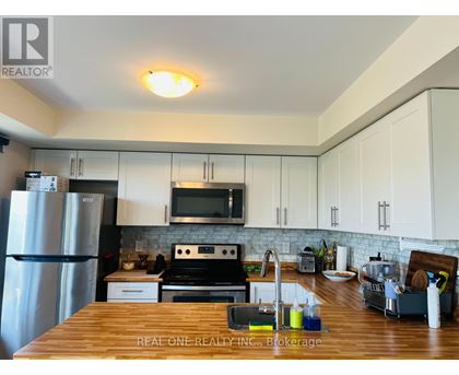 A kitchen with a wooden counter top and white cabinets.
