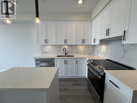 A kitchen with white cabinets and marble countertops.