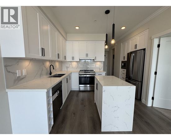 A modern kitchen with white cabinets and a central island.
