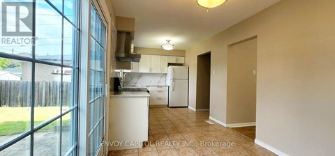 A realtor photo of a kitchen with a white fridge and a white couch.