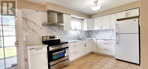 A kitchen with white cabinets and a black stove top oven.
