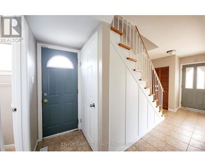 A hallway with a staircase and a blue door.
