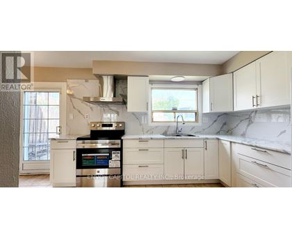 A kitchen with white cabinets and a marble countertop.
