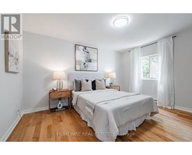 A bedroom with a large bed and a painting on the wall.
