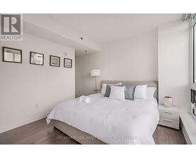 A bedroom with a large bed and pictures on the wall.