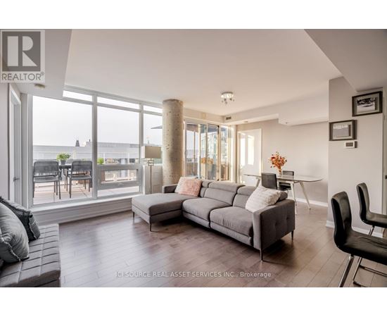 A living room with a grey couch and a large window.