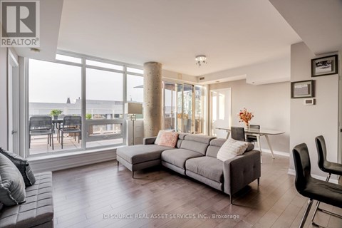 A living room with a grey couch and a large window.