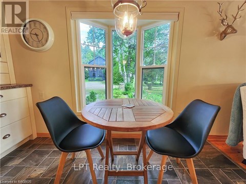 A dining room with a round table and chairs.