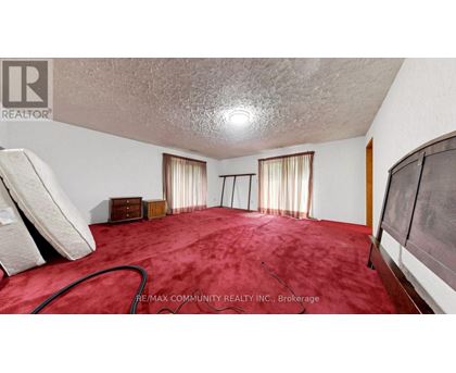 A bedroom with a red carpet and a white ceiling.